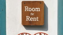 Wooden “Room for Rent” sign on white wall with teal framing and red decoration, symbolising the softening rental market